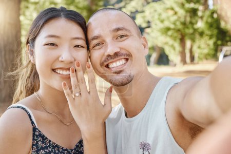 Photo for Selfie, engagement and portrait of couple in nature by outdoor park, garden or woods. Happy, smile and interracial engaged man and woman taking picture after romantic proposal with love and happiness. - Royalty Free Image