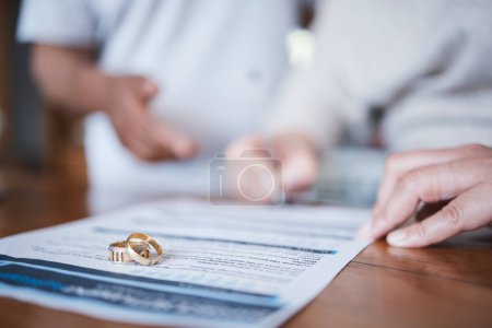 Photo for Family law, divorce and marriage court for couple with a contract, document or legal paperwork to sign agreement. Ring, deal and people together in conflict in an attorney office for a break up. - Royalty Free Image