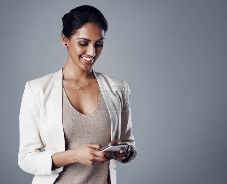 Photo for Business, happy and woman with a smartphone, connection and online reading against a grey studio background. Female person, administrator or model with a cellphone, mobile application or website info. - Royalty Free Image