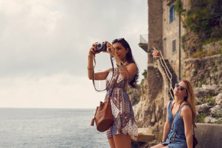 Téléchargez les photos : Voyage, tourisme ou amis touristiques prendre une photo en vacances, vacances ou week-end pour la mémoire. Photographie, vue ou femmes avec appareil photo à l'étranger pour visiter l'Italie en voyage d'aventure amusant. - en image libre de droit