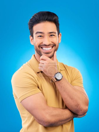 Photo for Happy, man and smile portrait in studio with Asian model with confidence and headshot. Blue background, male person and casual fashion with handsome and friendly guy with modern style and outfit. - Royalty Free Image