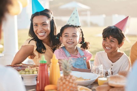Téléchargez les photos : Bonne famille au déjeuner ou une fête dans la nature pour un anniversaire, une célébration ou un barbecue en été. Rire, ensemble et une mère avec des enfants à une table dans un parc, manger et à un événement avec de la nourriture. - en image libre de droit