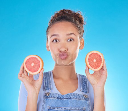 Photo for Portrait, kiss and woman with grapefruit in studio isolated on a blue background. Face, fruit and person with food for healthy diet, nutrition or wellness, eating and vitamin c, benefits and vegan - Royalty Free Image