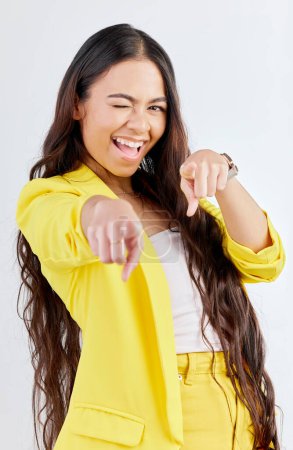Photo for Portrait, pointing and wink with an excited woman in studio on a gray background to choose you. Smile, hands and selection with a happy young female model in yellow clothes to vote on a decision. - Royalty Free Image