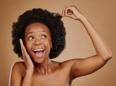 Foto de Mujer negra excitada, cuidado del cabello y afro para la belleza en el estudio aislado sobre un fondo marrón. Crecimiento, peinado o modelo africano feliz con cosméticos naturales después del tratamiento de salón para un bienestar saludable. - Imagen libre de derechos