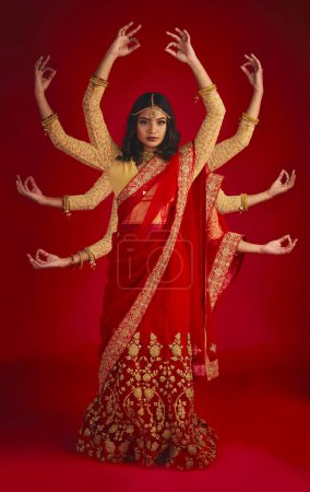 Photo for Indian woman, studio and culture with mudra, portrait and magic for culture, yoga and fashion by red background. Girl, model and beauty for fantasy, jewellery and art with clothes for festive event. - Royalty Free Image
