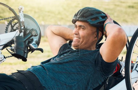 Foto de Ciclismo, fitness y hombre con discapacidad entrenando para competir con sonrisa, motivación y ejercicio en bicicleta. Felicidad, entrenamiento y persona en bicicleta reclinada para pista de carreras al aire libre para el desafío - Imagen libre de derechos