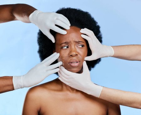 Photo for Confused, hands and black woman with check on a blue background for surgery or dermatology problem. Frustrated, African girl and doctors and inspection of skin for botox isolated on a studio backdrop. - Royalty Free Image