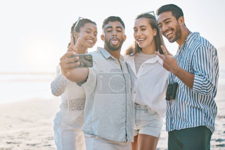 Photo for Happy friends, selfie and beach for memory, photo or picture in goofy or silly fun together in nature. Group of people with smile and peace sign on ocean coast for vlog, online post or social media. - Royalty Free Image