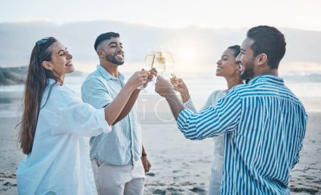 Téléchargez les photos : Amis, souriez et trinquez avec du champagne sur la plage, en vous amusant et en vous liant au coucher du soleil. Océan, groupe et personnes acclamations avec verre à vin, alcool et boisson pour la célébration en vacances, fête d'été et mer - en image libre de droit