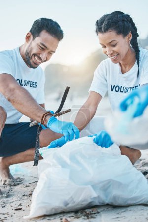 Téléchargez les photos : Volontaire, homme et femme nettoyage plage pour la journée mondiale de la terre, soins et gentillesse pour la nature et l'environnement. Aide, recyclage et personnes heureuses à ngo collecter les déchets plastiques et la pollution des sables océaniques - en image libre de droit