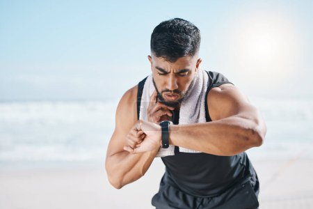 Photo for Man, fitness and checking watch for pulse, heart rate or performance on break after workout on the beach. Fit, active and sporty male person with wristwatch for monitoring body exercise by the ocean. - Royalty Free Image