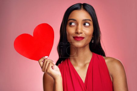 Photo for Woman, paper heart and thinking in studio with makeup, beauty and romantic sign by red background. Young girl, ideas and cardboard emoji with love for cosmetics, valentines day date and aesthetic. - Royalty Free Image