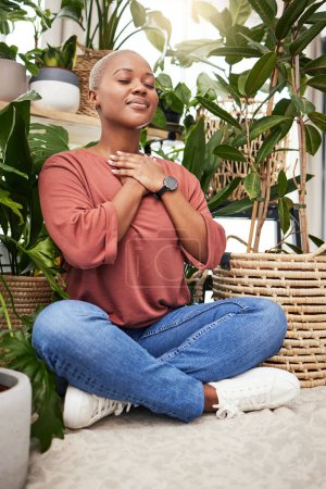 Photo for Calm, peace and young woman by plants for breathing exercise in meditation in a greenery nursery. Breathe, gratitude and African female person with a relaxing zen mindset by indoor greenhouse garden - Royalty Free Image