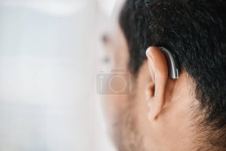 Téléchargez les photos : Appareil auditif, gros plan ou oreille de l'homme handicapé du dos sur l'espace de maquette. Personne sourde, dispositif médical ou implant d'ondes sonores, audiologie ou aide à l "écoute, accessoire ou support. - en image libre de droit