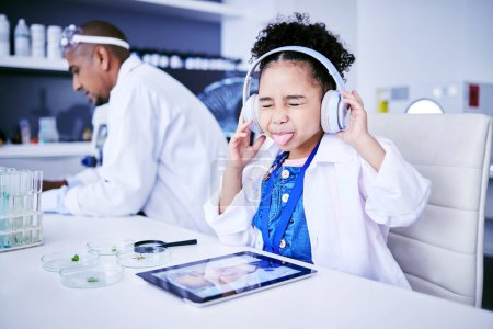 Photo for Crazy, lab and child with music and tablet for science with a father or scientist for work or learning. Funny, future and a comic girl streaming audio on tech with a person for innovation in medicine. - Royalty Free Image