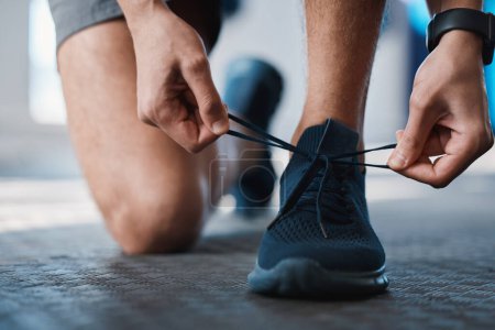 Photo for Fitness, shoes and tie with a sports man in the gym getting ready for a cardio or endurance workout. Exercise, running and preparation with laces of a male athlete or runner at the start of training. - Royalty Free Image