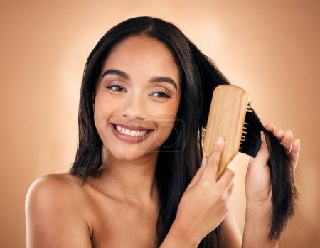 Photo for Hair care, brush and happy woman with beauty isolated on a brown background in studio. Salon, smile and model with a wood grooming product for natural aesthetic, hairdresser or hairstyle for wellness. - Royalty Free Image