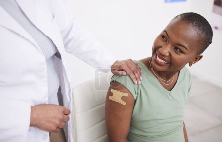 Photo for Doctor, patient and plaster on arm for vaccine, medicine and protection for virus with happy black woman in clinic. Medic, african girl and smile for helping hand, injection and strong immune system. - Royalty Free Image