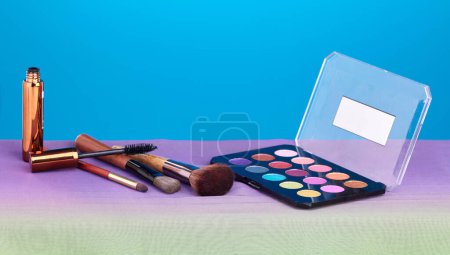 Photo for Makeup, product and palette for color in studio, brush and cosmetics for beauty, mock up and blue background. Powder, mascara and skincare with transformation, change and eyeshadow for aesthetic. - Royalty Free Image