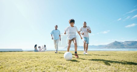 Photo for Family, soccer and men with ball in a park for fun, playing and bonding in nature on blue sky background. Sports, games and boy child with father and grandfather outdoors for weekend football match. - Royalty Free Image