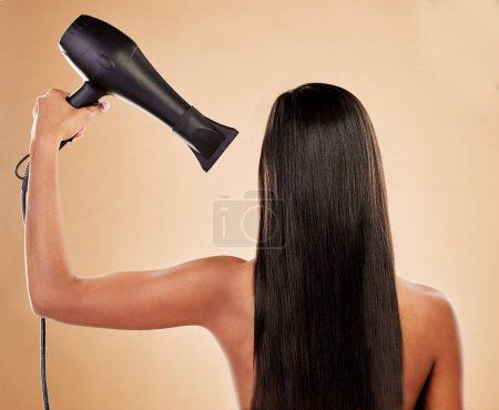 Photo for Hair, beauty and back view, woman with hairdryer and keratin treatment with heat on studio background. Female model, cosmetics and haircare with salon hairstyle, equipment and blow dry with shine. - Royalty Free Image