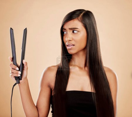 Hair straightener, woman is scared and beauty, hairstyle and appliance fail on studio background. Keratin treatment, problem with electric flat iron and female model, haircare crisis and treatment.