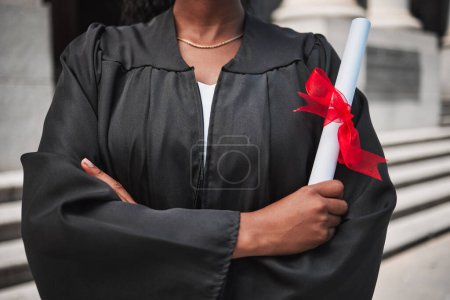 Foto de Educación, graduación y certificado con brazos de estudiante cruzados en el campus, confiados en su logro. Diploma, universidad o universidad con un graduado africano de pie al aire libre en una ceremonia. - Imagen libre de derechos
