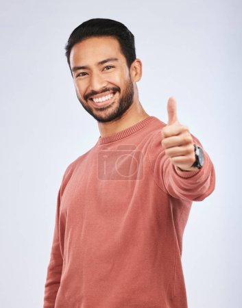 Photo for Thumbs up, portrait and man vote for success in studio, white background and thank you. Happy asian male model, thumb emoji and support of winning, like and motivation of feedback, good review or yes. - Royalty Free Image