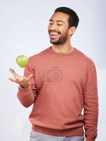 Photo for Studio, fruit throw and happy man with apple product for self care diet, clean healthy gut or nutrition meal, vitamin or detox. Happiness, nutritionist food or hungry person smile on white background. - Royalty Free Image