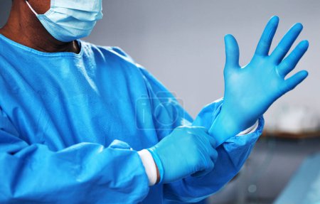 Photo for Doctor with gloves, health and surgeon with PPE, safety and protection from bacteria, operating room and closeup. Medical professional, surgery and treatment with person in hospital and healthcare. - Royalty Free Image