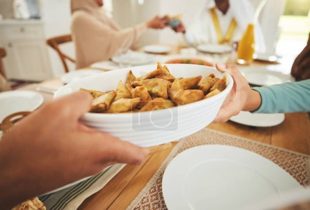 Foto de Comida, samosa y musulmana con manos de familia a la mesa para eid mubarak, celebración islámica y almuerzo. Festival de Ramadán, cultura e iftar con el cierre de personas en casa para ayunar, islam o religión. - Imagen libre de derechos