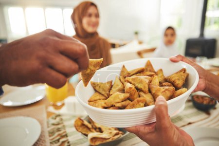 Téléchargez les photos : Nourriture, samosa et musulman avec les mains des gens à table pour moubarak Aïd, célébration islamique et déjeuner. Festival du Ramadan, culture et iftar avec gros plan de la famille à la maison pour le jeûne, l'islam ou la religion. - en image libre de droit