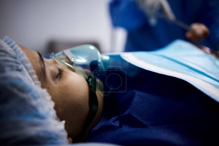 Téléchargez les photos : Médecin, femme endormie ou malade avec un masque à oxygène ou respiratoire pour la récupération des soins de santé dans le lit d'hôpital. Chirurgien médical, anesthésie ou patient avec appareil respiratoire pour la ventilation en cas d'urgence. - en image libre de droit
