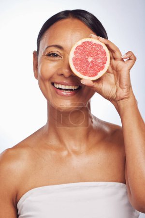 Photo for Skincare, face and mature woman with grapefruit in studio isolated on a white background. Portrait, natural fruit and happy model with food for nutrition, wellness and healthy diet for anti aging - Royalty Free Image