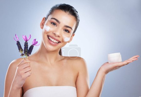 Photo for Beauty, cream and woman with lavender flower in studio for skincare product and natural glow. Portrait of happy female model on a gradient background for facial shine, cosmetics and face moisturizer. - Royalty Free Image