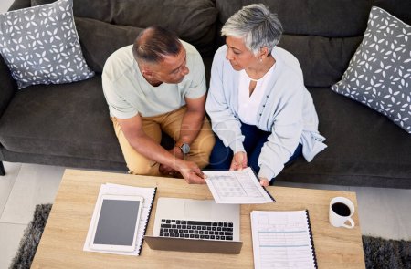 Photo for Senior couple, tax documents and laptop in home living room for discussion, planning and finance. Elderly man, old woman and paperwork for financial compliance in top view, lounge sofa and retirement. - Royalty Free Image