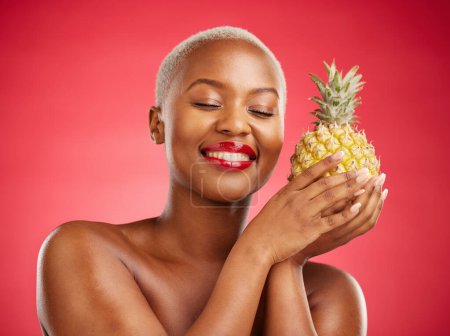 Photo for Pineapple, beauty and face of a happy woman in studio for healthy food, diet or fruit. Black female model with makeup on red background for wellness glow, natural cosmetics and tropical skin care. - Royalty Free Image