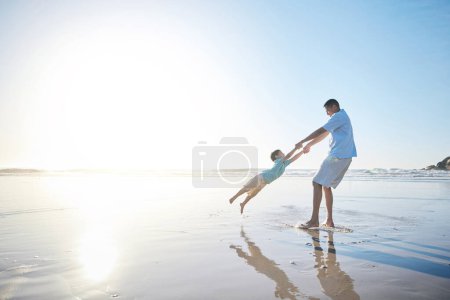 Photo for Family, father and spinning a child at the beach for fun, adventure and play on holiday. A man and young kid holding hands on vacation at the ocean, nature or outdoor with mockup banner space in sky. - Royalty Free Image