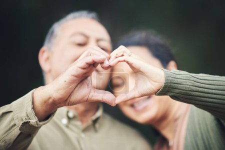 Photo for Heart, hands and a senior couple in a house for love, care and showing an emoji together. Happy, trust and an elderly man and woman with a gesture for romance, marriage or valentines day with bokeh. - Royalty Free Image