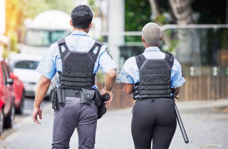 Photo for Police, people or walking in city for safety, law enforcement and urban patrol from the back. Man, woman and team of public service cops, metro security guard or protection in street together outdoor. - Royalty Free Image