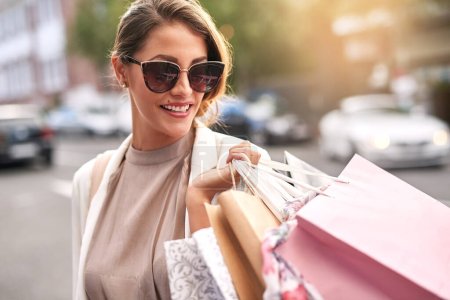 Fashion, shopping bag or rich girl in city or urban street for boutique retail sale or clothes discount deals. Sunglasses, financial freedom or trendy customer walking on road with luxury products.