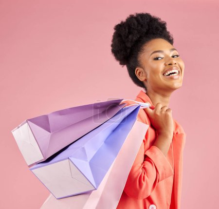Photo for African woman, studio portrait and shopping bag with discount, sale or excited smile by pink background. Young gen z girl, promotion and happy for deal, retail customer experience or fashion for gift. - Royalty Free Image