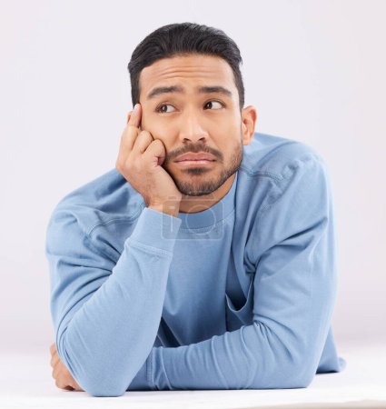 Photo for Thinking, remember and young man in a studio resting on his arms with a contemplating facial expression. Happy, smile and Indian male model with question or dreaming face isolated by white background. - Royalty Free Image