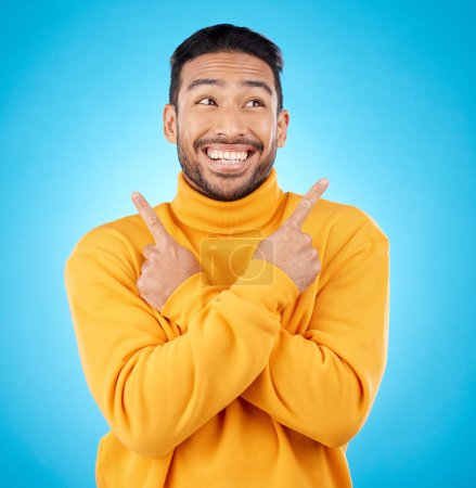 Photo for Happy, asian man and hands pointing in studio for choice, deal or sign up decision on blue background. Smile, direction and Japanese guy with recommendation, suggestion or coming soon launch platform. - Royalty Free Image