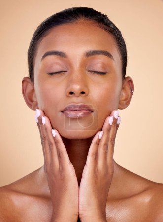 Photo for Relax, skincare or natural woman with wellness, beauty or facial glow with dermatology cosmetics in studio. Hands, background or face of Indian girl model resting with shine, eyes closed or self love. - Royalty Free Image