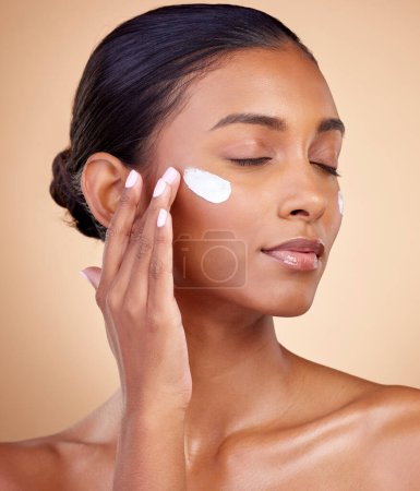 Photo for Face, cream and woman with eyes closed for skincare cosmetics, dermatology or aesthetic makeup on studio background. Indian female model, lotion and facial sunscreen for clean beauty, glow and shine. - Royalty Free Image