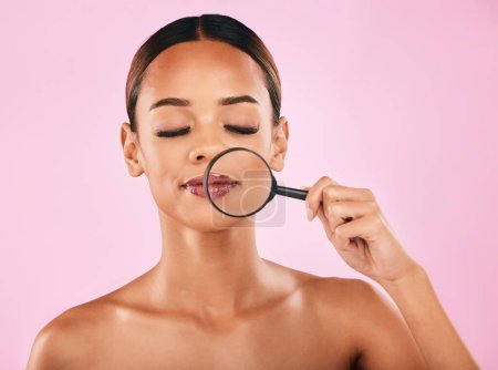 Photo for Woman, face and magnifying glass, beauty and investigation, skincare and makeup isolated on pink background. Search, zoom in on pores and check skin with glow, female model and dermatology in studio. - Royalty Free Image