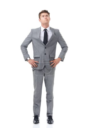 Photo for Ready to climb the corporate ladder. A young businessman standing with his hands on his hips looking upwards - Royalty Free Image
