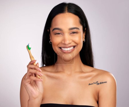 Photo for Happy woman, portrait and teeth with toothbrush for dental, cleaning or hygiene against a grey studio background. Face of female person with bamboo tooth brush in clean oral, mouth and gum healthcare. - Royalty Free Image